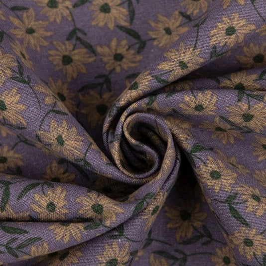 A close-up of a purple fabric with a repeating floral pattern in beige and green, styled in a spiral drape.