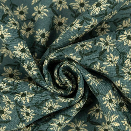 A close-up of draped fabric with a repeating floral print in muted teal-green and cream, arranged in a spiral fold.