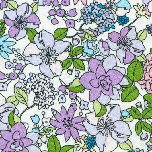 A close-up of a floral fabric pattern featuring purple, lavender, light blue, and pink flowers with green leaves on a white background.