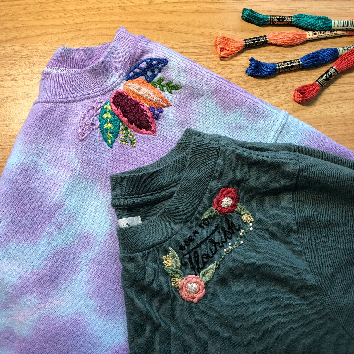 Emroidered flowers on the neckline of two t-shirts created at an embroidery class at Wyldwood Creative Renton