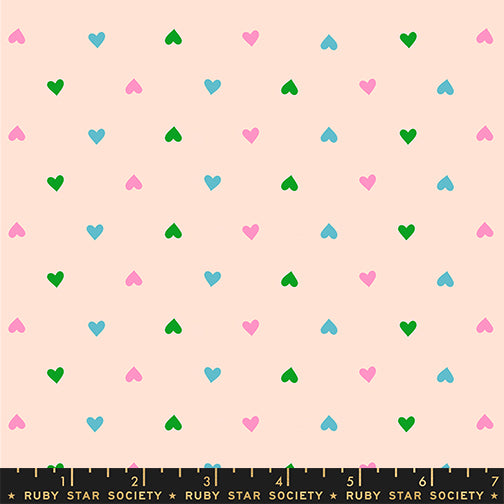 Pattern of small colorful hearts on a light pink background with a ruler at the bottom.