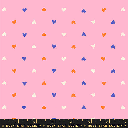 Pattern of colorful hearts on a pink background with a ruler at the bottom.