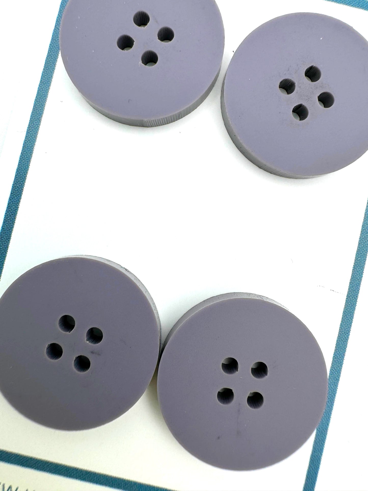 a close up of a set of 4 purple buttons on a paper card