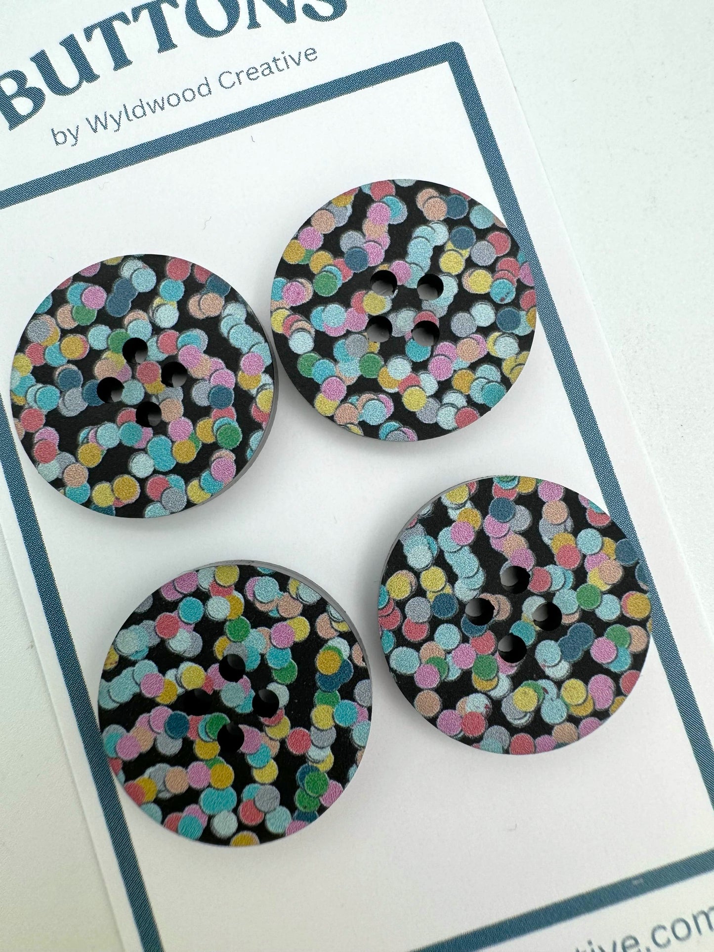 a set top 4 buttons on a paper card against a white background