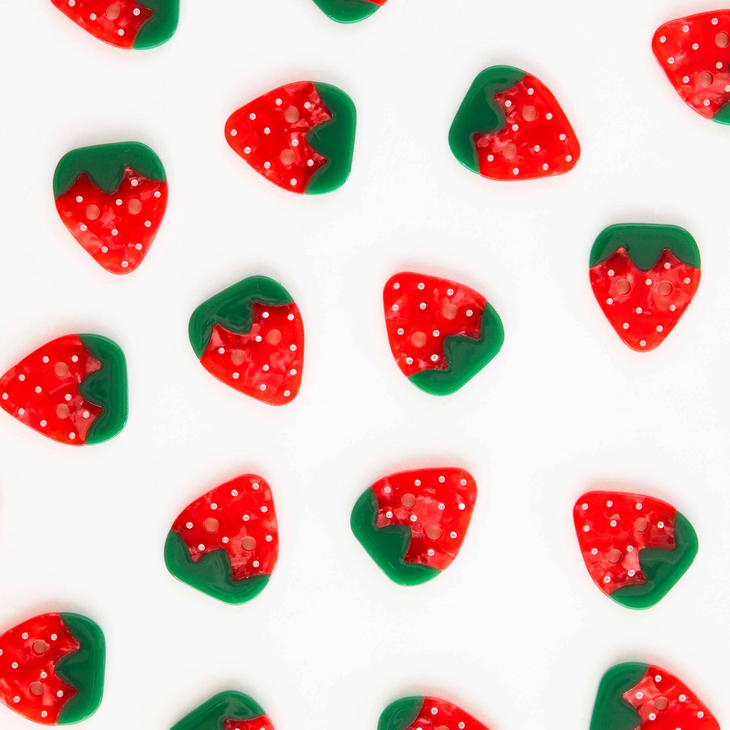 Several strawberry buttons scattered on a white background