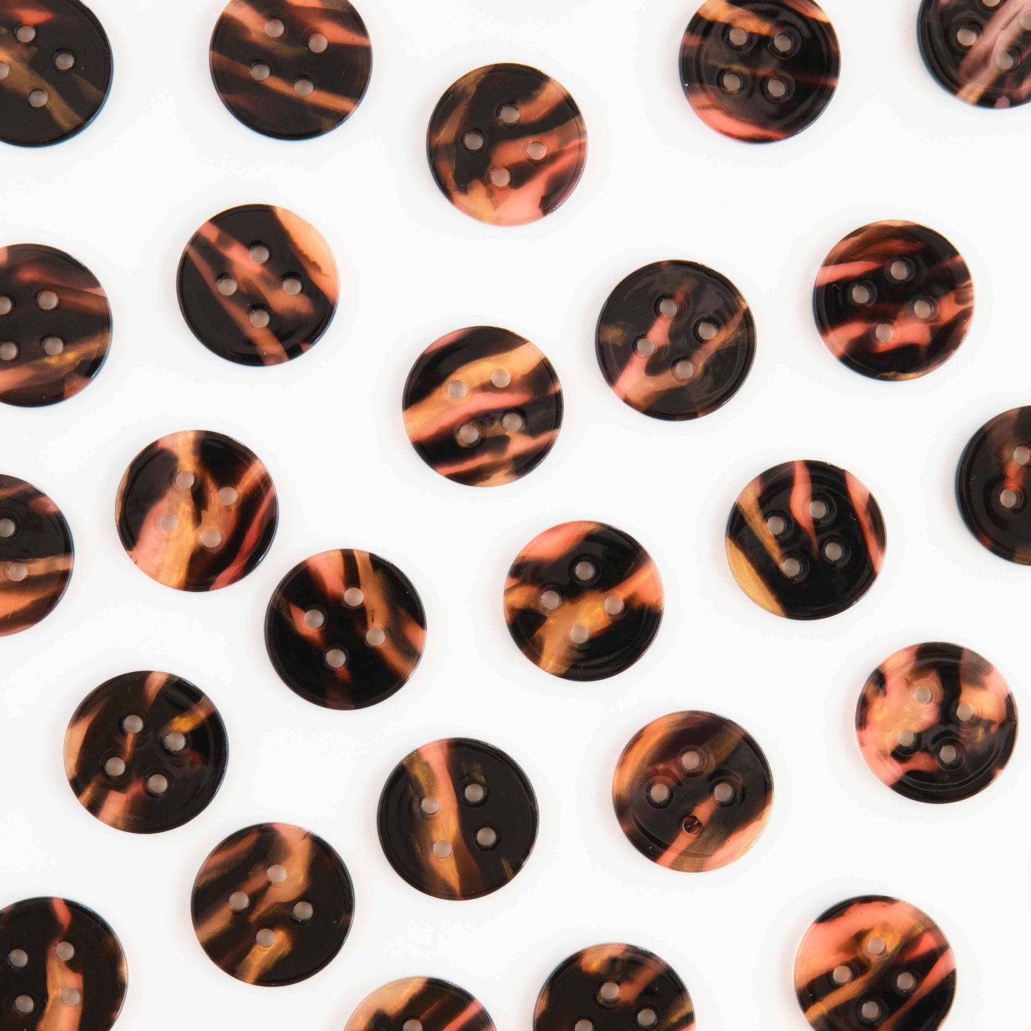 Several tortoise shell buttons scattered against a white background