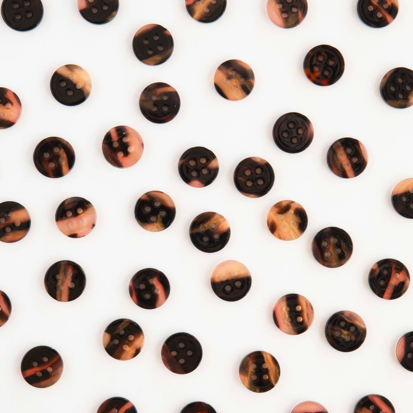 Several tortoise shell buttons scattered on a white background