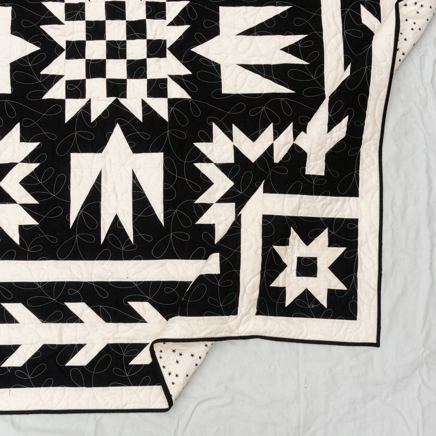 black and white geometric quilt pattern, corner edge folded over