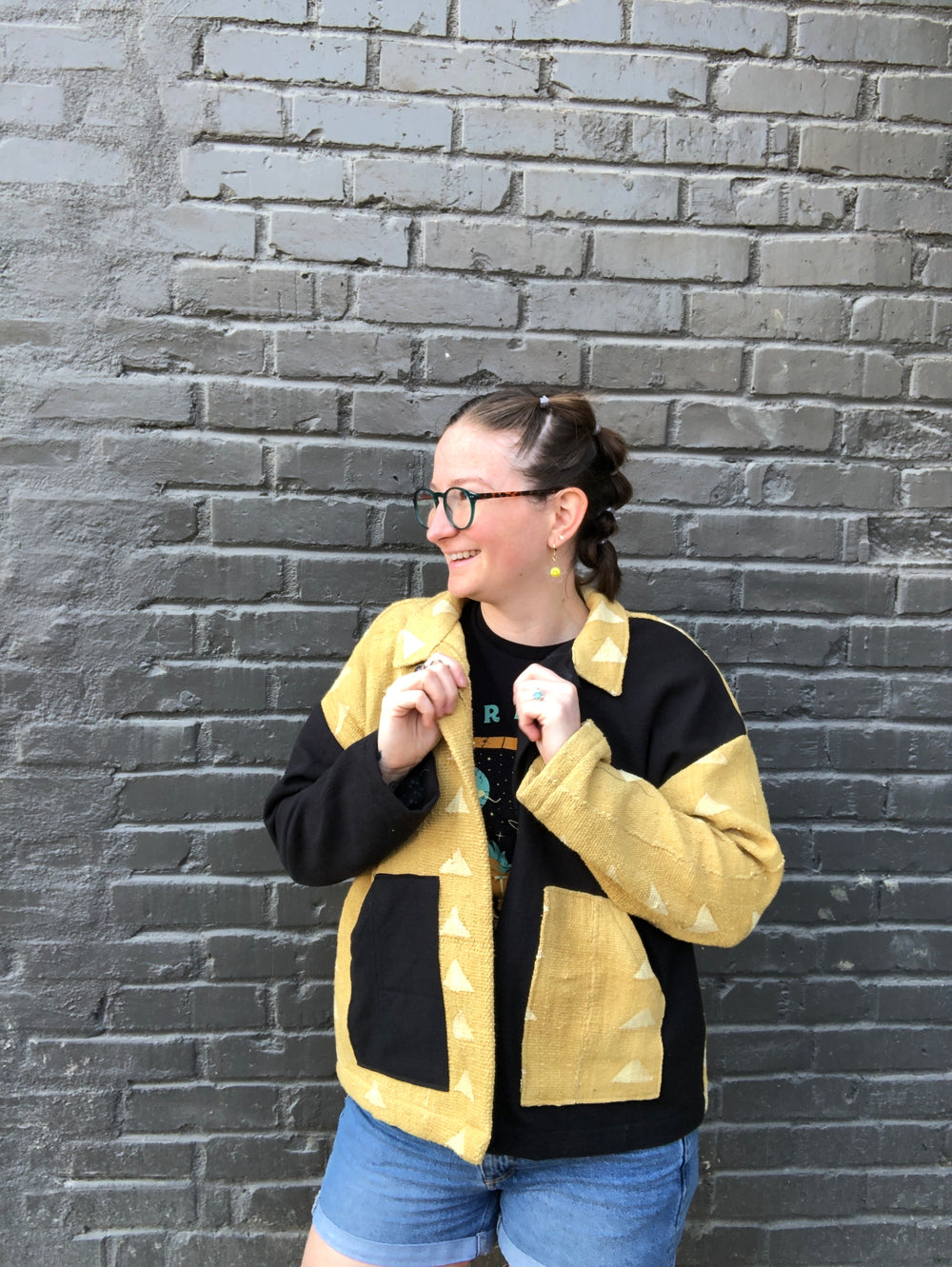 Class participant showing off her black and yellow ilford jacket sewn in an intermediate class at Wyldwood Creative in Renton