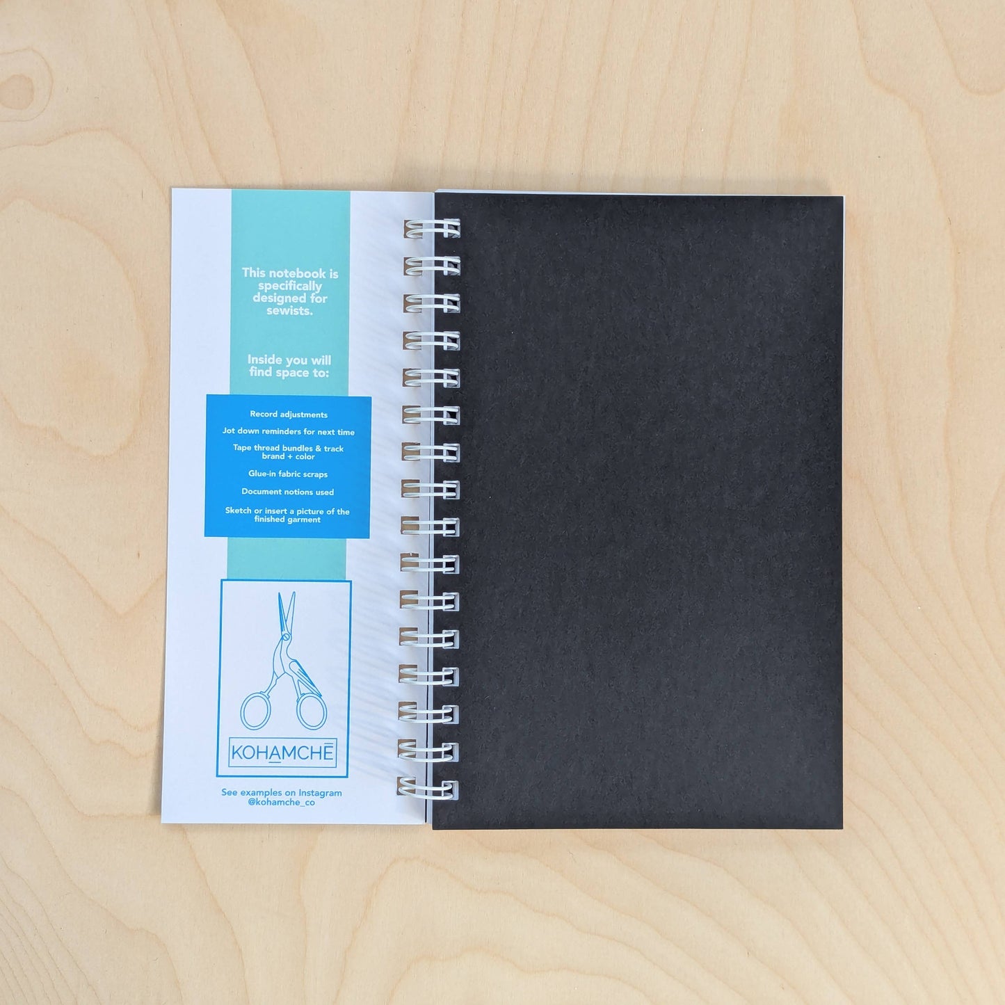 Black notebook with a spiral binding on a wooden surface