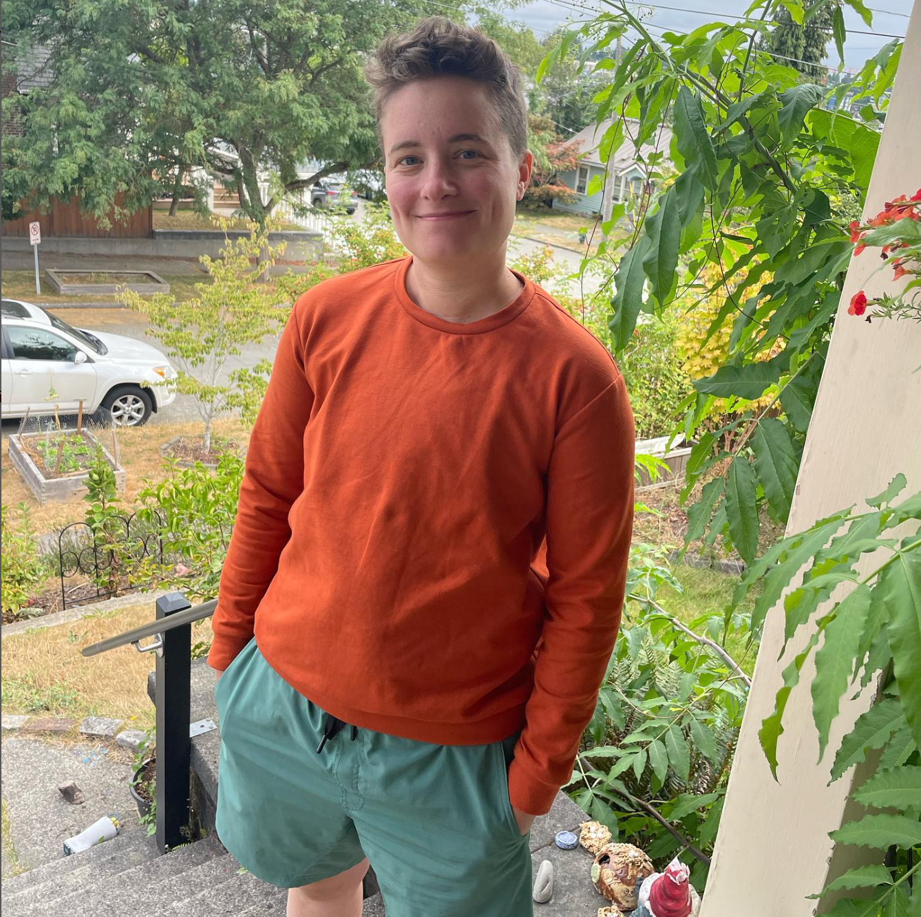 Model outside on a porch wearing an orange long sleeve Jackson t-shirt sewn in a sewing class at Wyldwood Creative in Renton