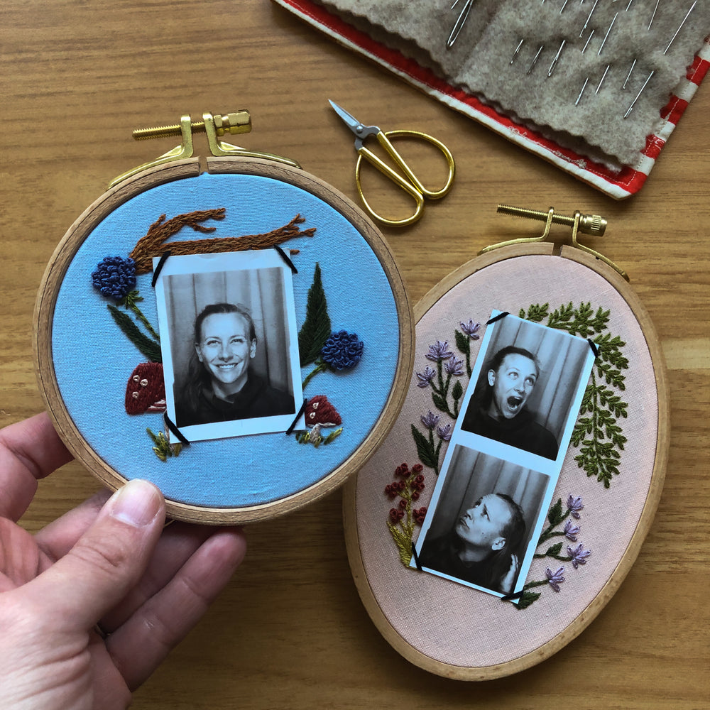 
                      
                        Close up of mini embroidery frames with floral embroidery and Photo Booth pictures displayed inside.
                      
                    