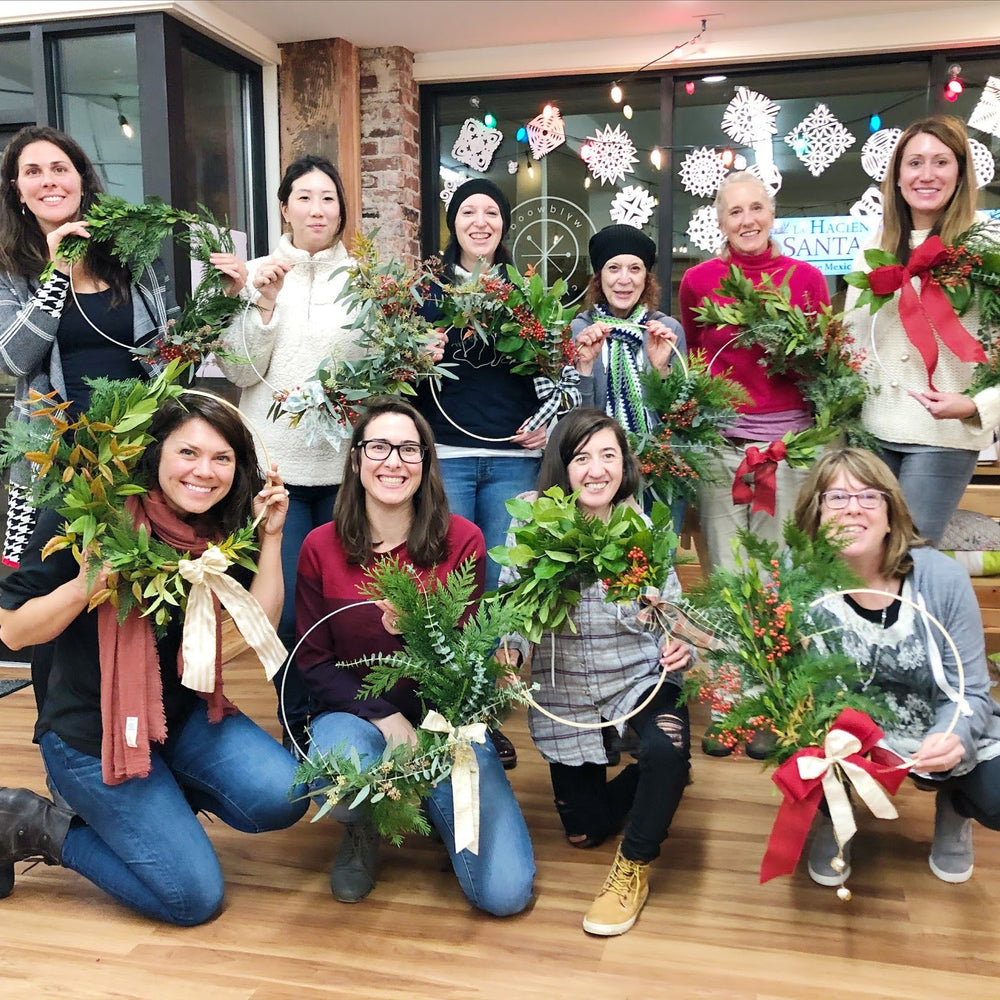 group of people holding their own wreath