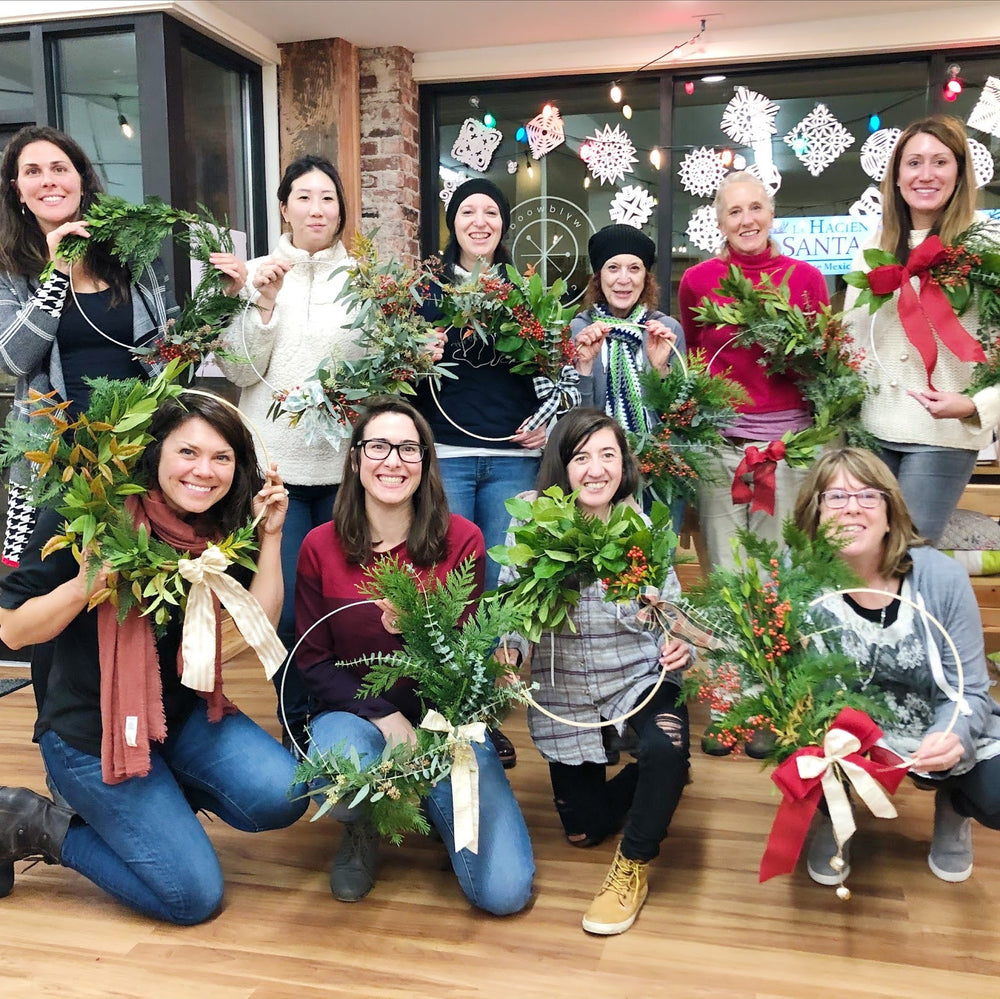 group of people holding their own wreath